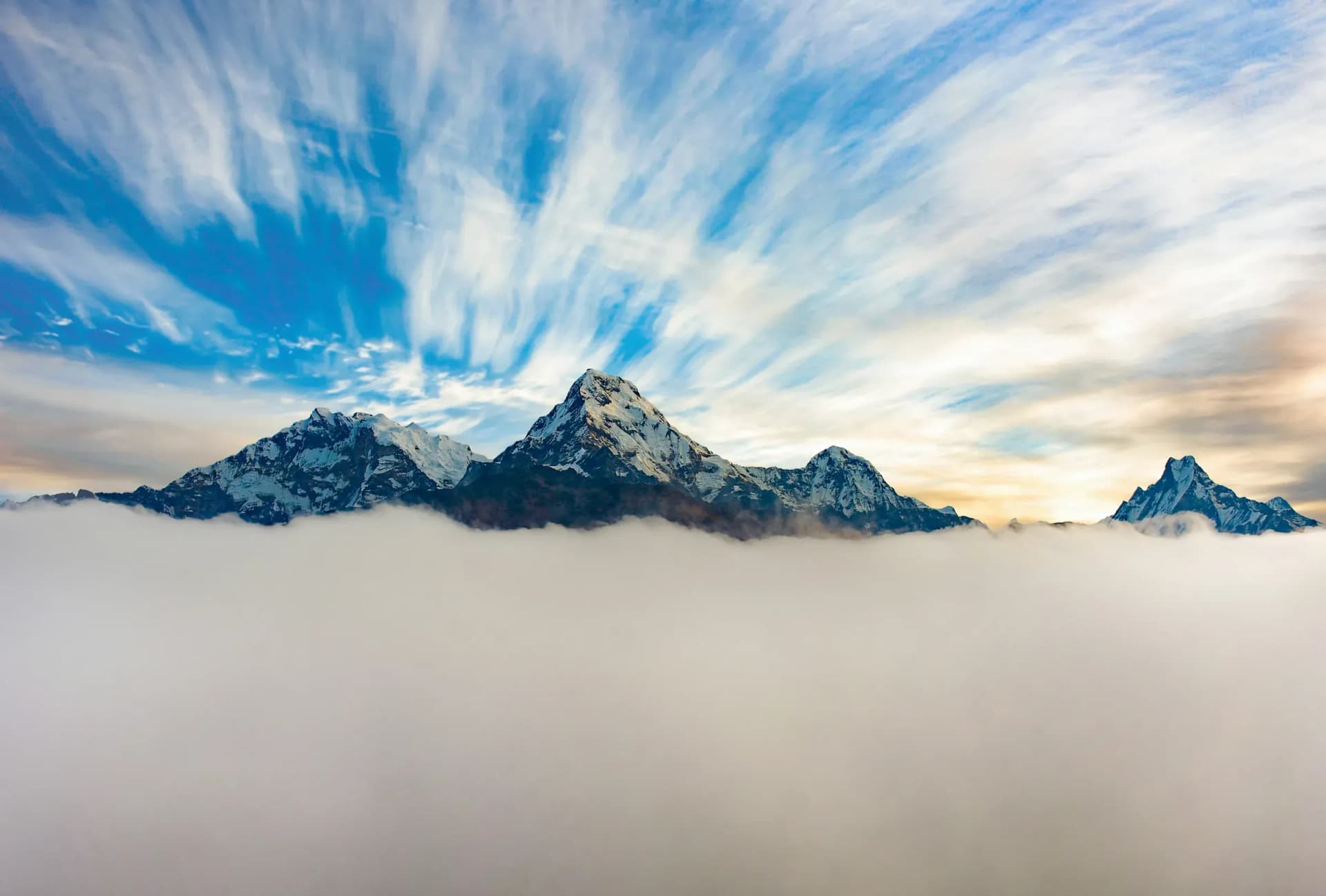 Himalayan peaks rising above a sea of clouds at dawn