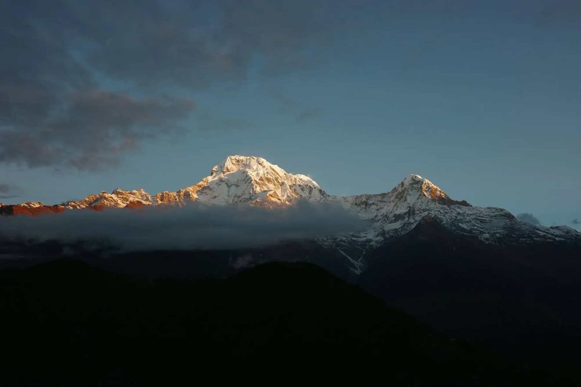 Dawn light on Annapurna South above a band of cloud