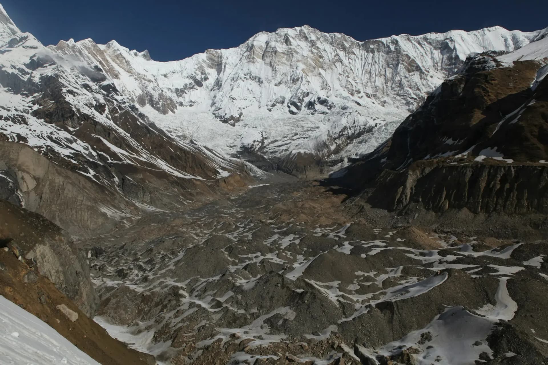 A vast snow face above a glacier moraine in the Annapurna Sanctuary