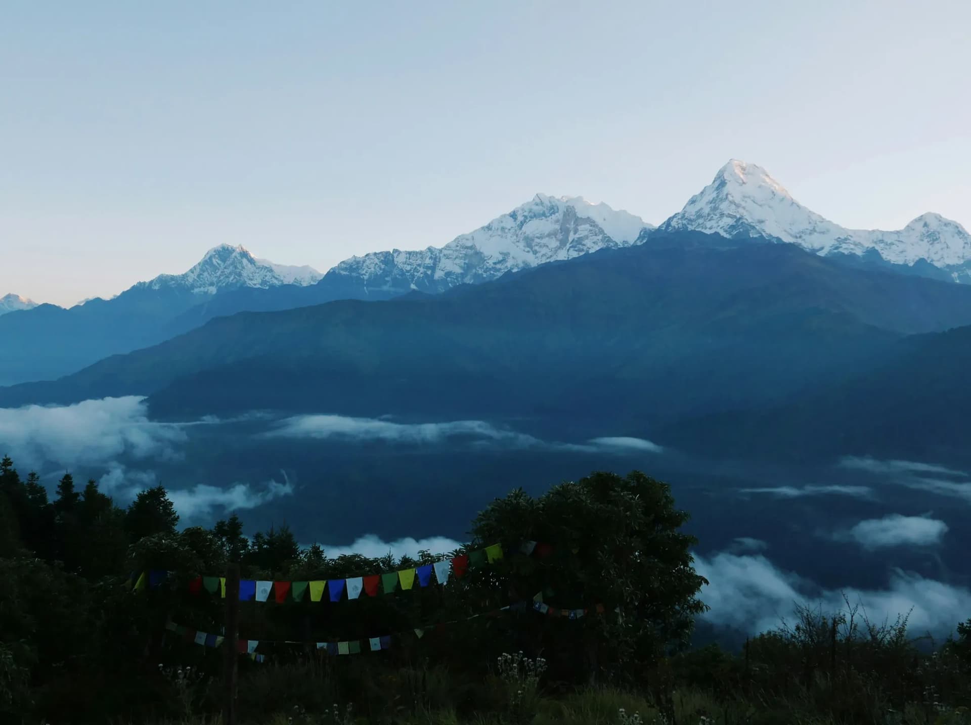 Prayer flags and Himalayan peaks above the morning clouds