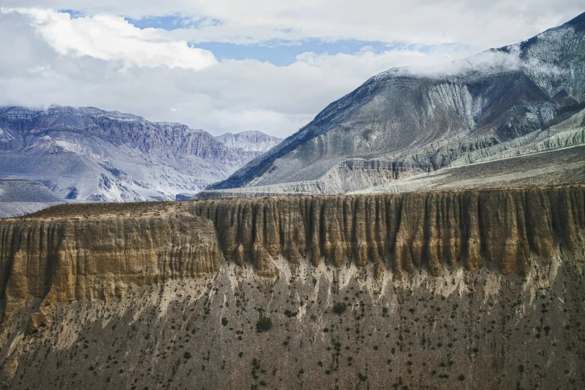 Eroded cliffs and snow-dusted peaks in Upper Mustang