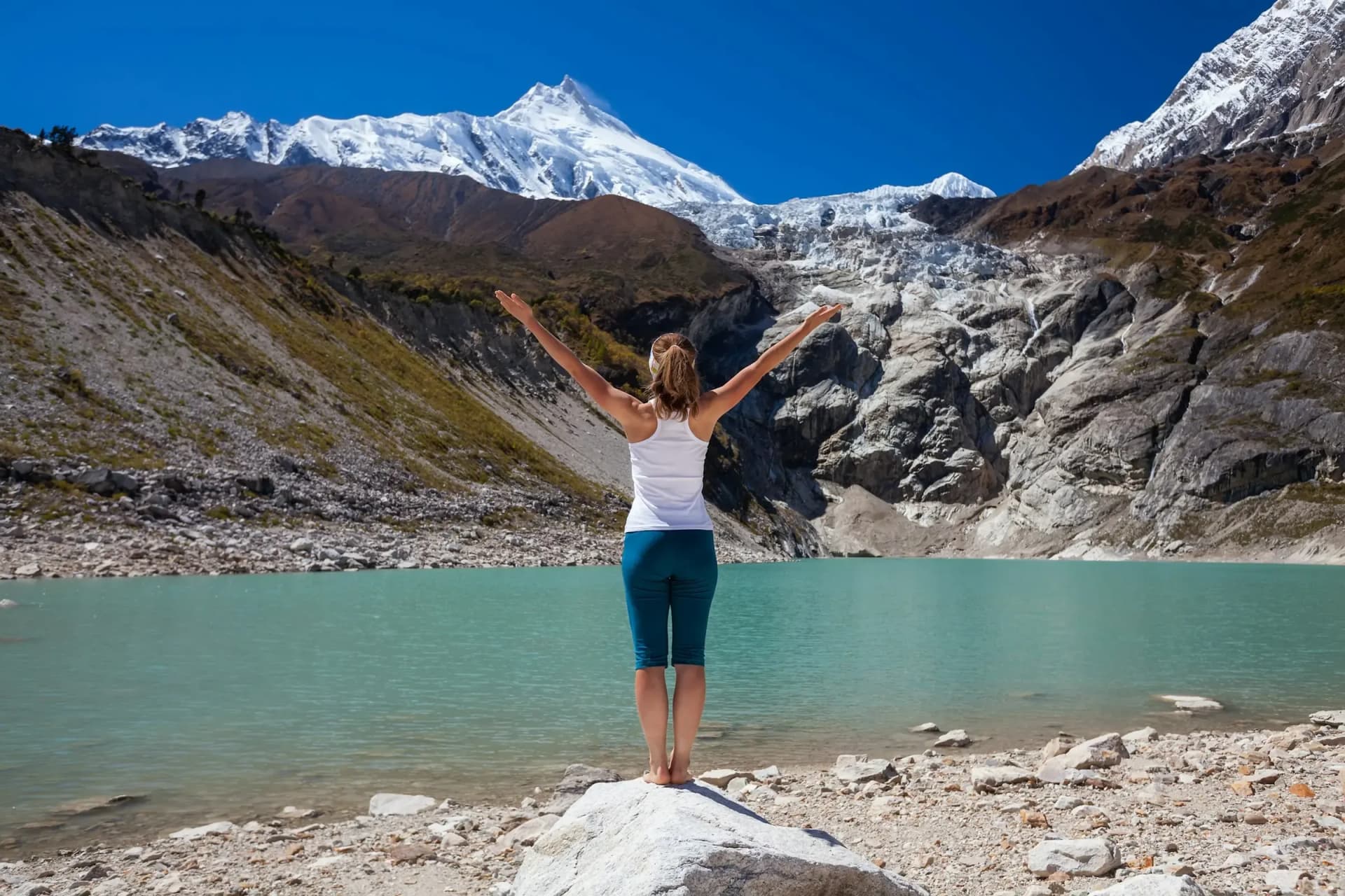 Yoga beside a glacial lake below Himalayan peaks in Nepal