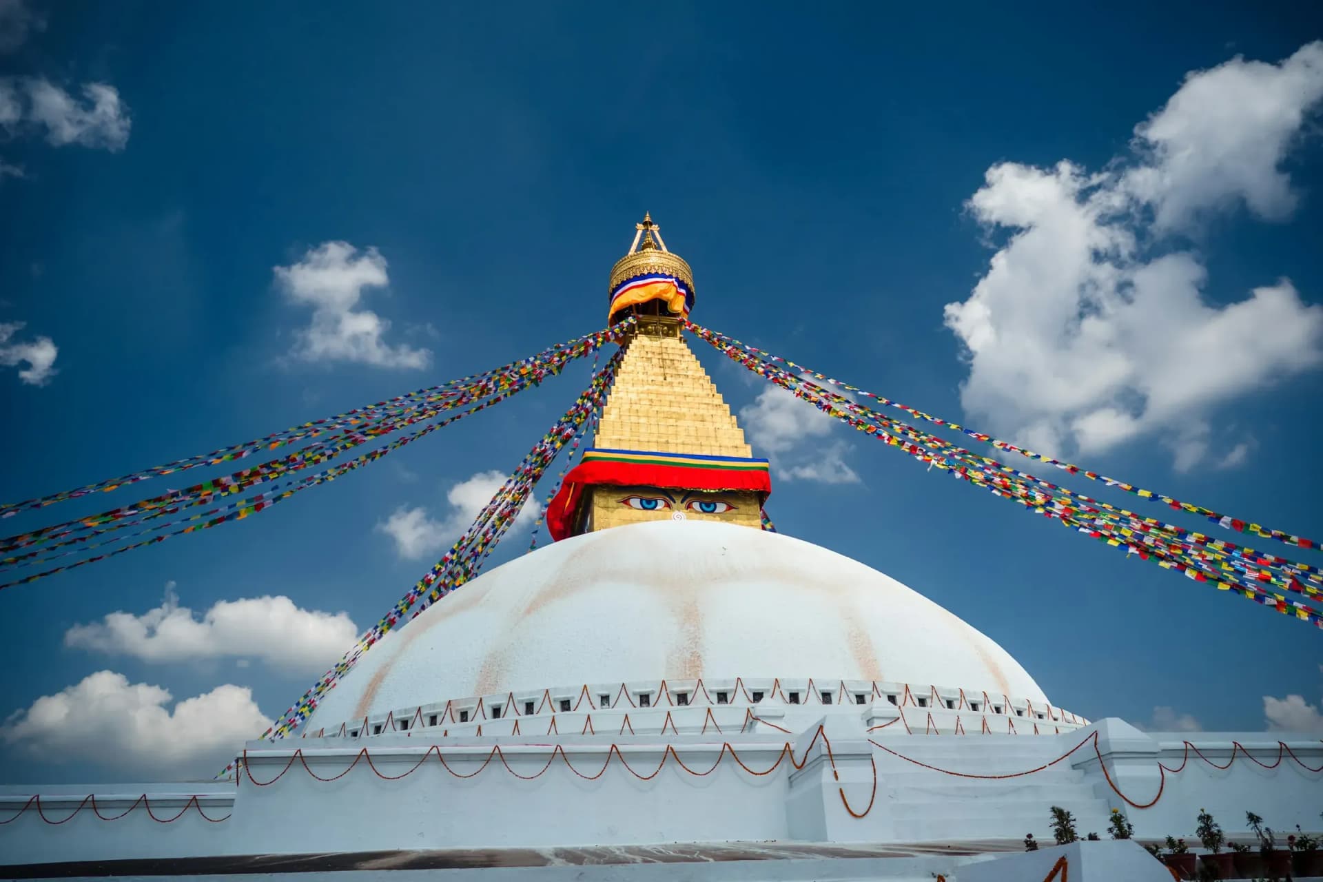 Boudhanath Stupa with prayer flags against a blue sky, Kathmandu