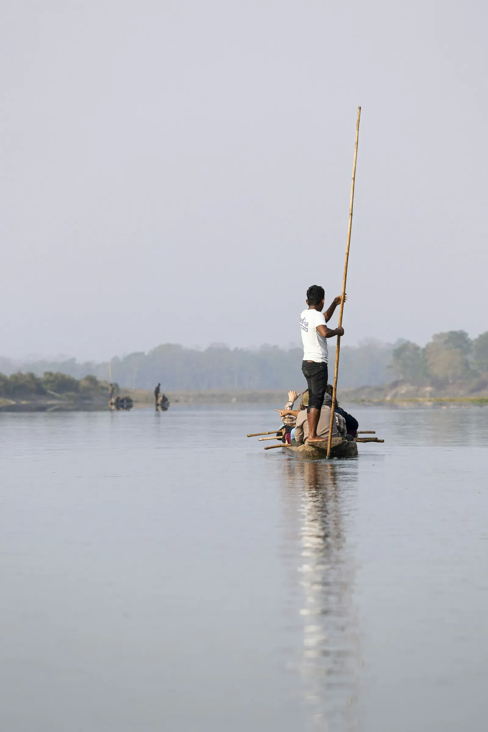 Boatman poling a dugout canoe on the Rapti River, Chitwan