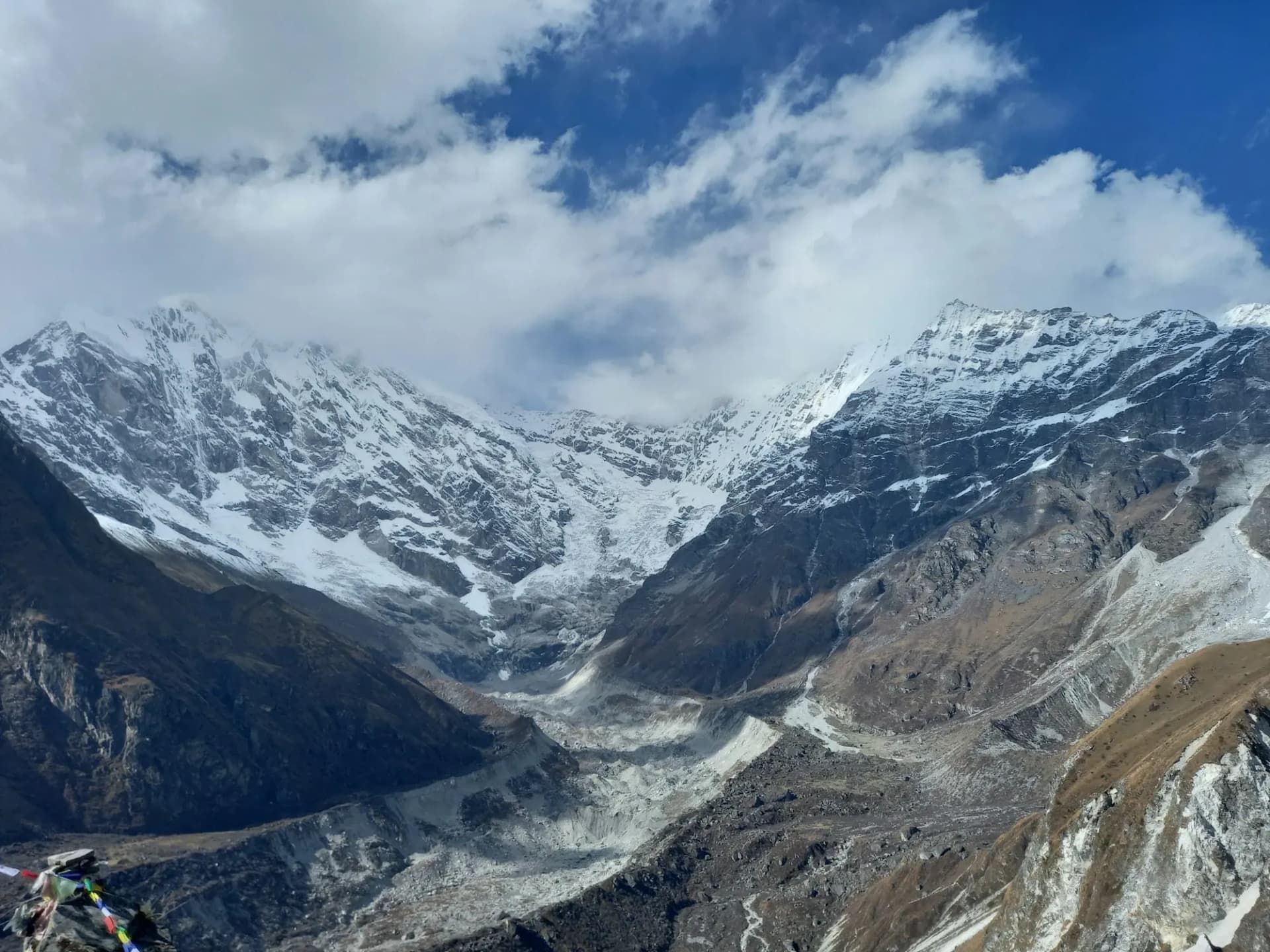 Snow peaks and a glacier valley under breaking cloud