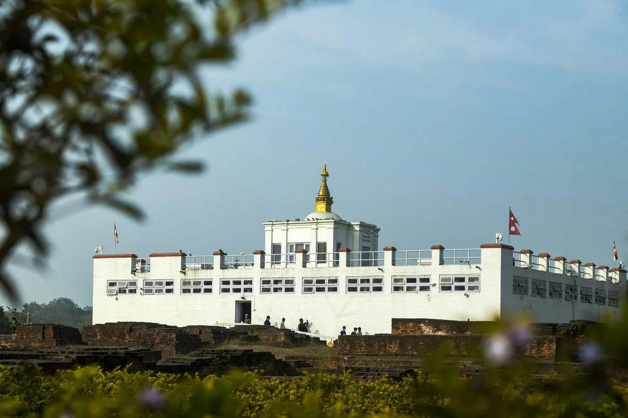 The white Maya Devi Temple and ancient brick ruins in Lumbini