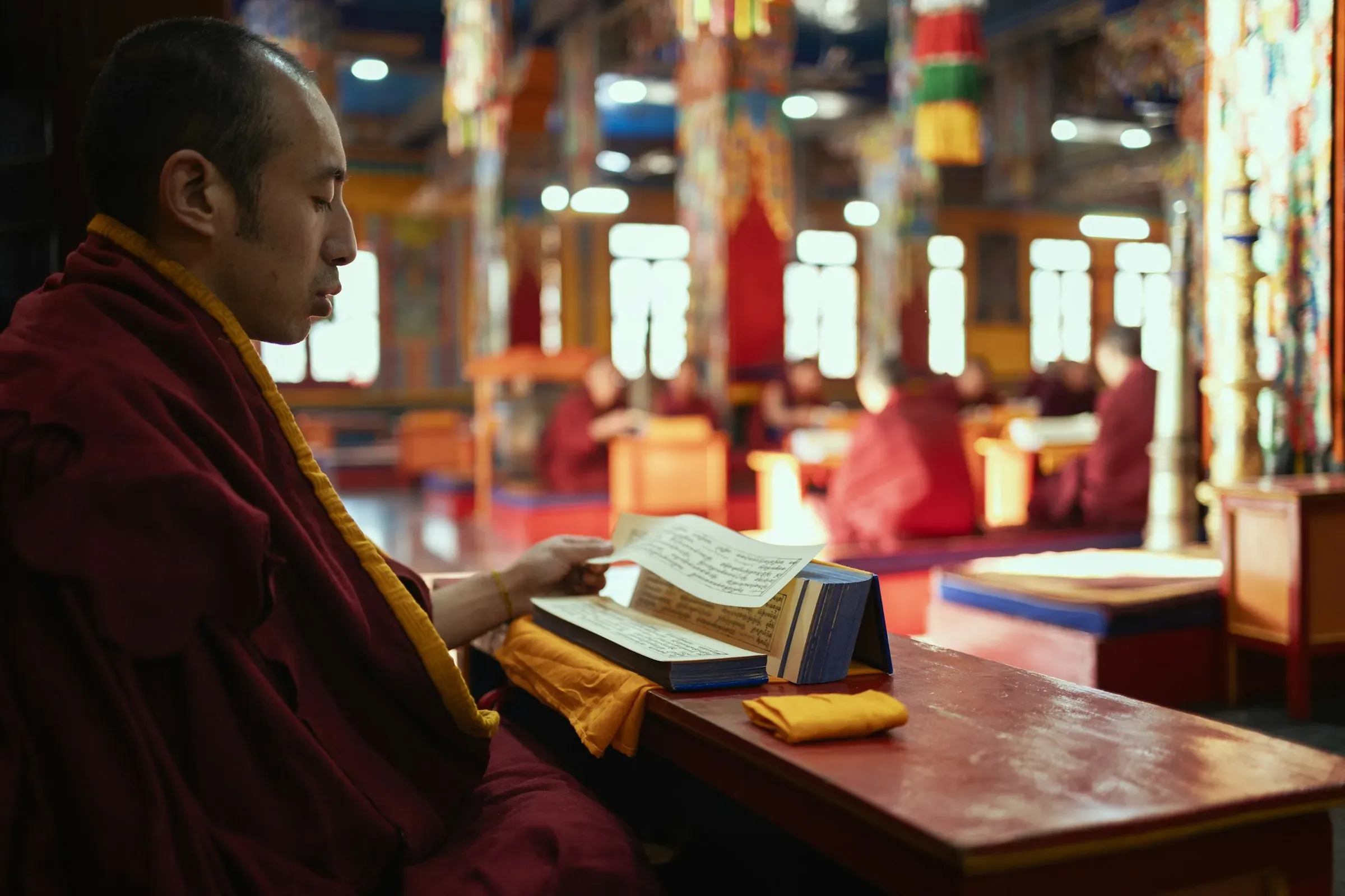 A monk reading scripture inside a Tibetan Buddhist monastery
