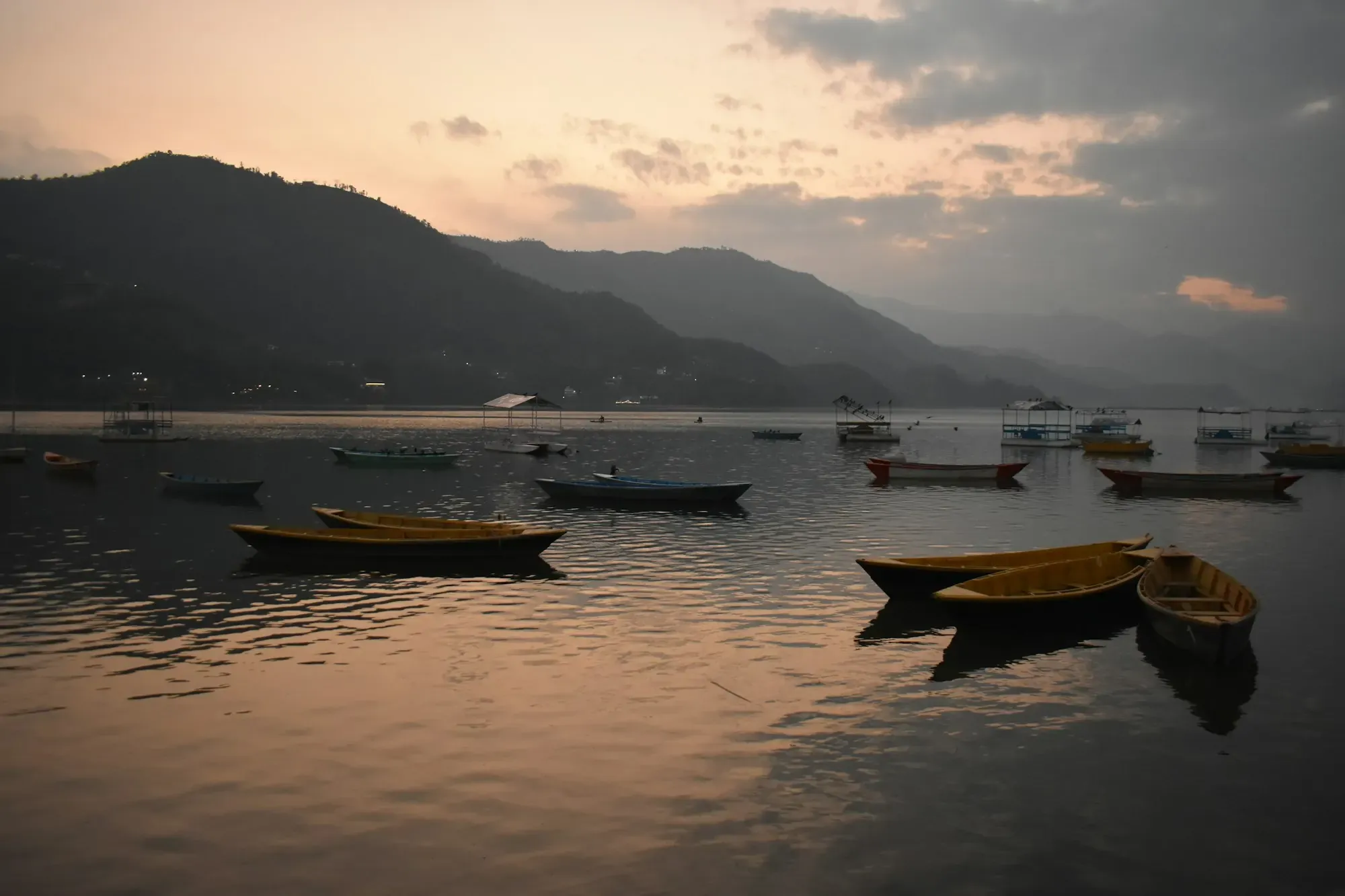 Wooden rowing boats on a calm lake at dusk