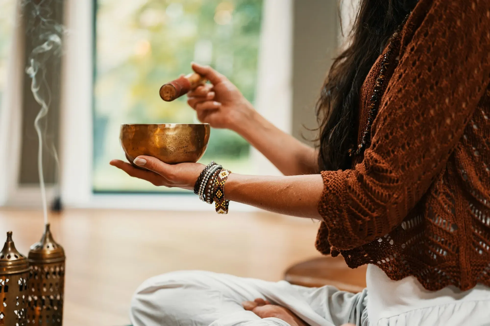 Brass singing bowl and incense in a quiet sound-healing session